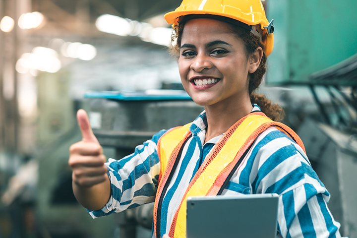 Women with hard hat looking at camera with thumbs up
